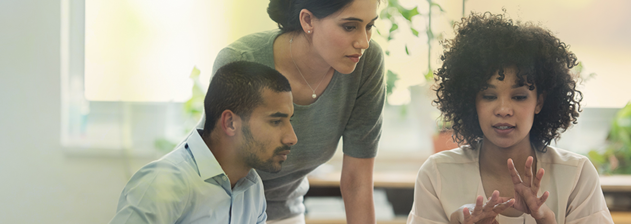 image of 3 people having a discussion and collaborating